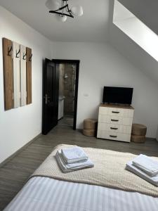 a white room with a bed and a television at Casa Tică in Vama Buzăului +20 photos