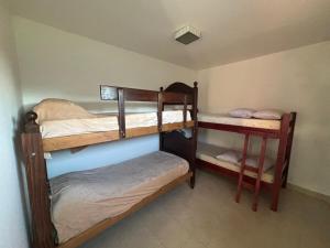 a room with three bunk beds in a room at Casa con pileta cerca de Salta in Salta
