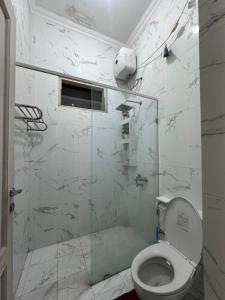 a bathroom with a toilet and a glass shower at RBD Guest House in Ungaran +21 photos