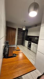 a kitchen with white cabinets and a wooden floor at Noclegi Tyczyn in Tyczyn +14 photos
