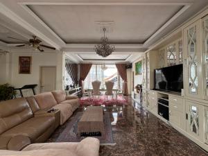a living room with a couch and a tv at RBD Guest House in Ungaran