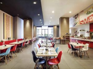a dining room with tables and chairs in a restaurant at Ibis Jakarta Harmoni in Jakarta