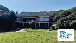 a large house with a sign in front of it at Dolphin Villa in Gqeberha
