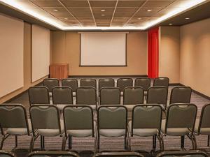 a conference room with chairs and a whiteboard at ibis Jundiai Shopping in Jundiaí