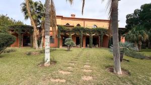 an orange house with palm trees in the yard at Royal Moroccan House in Marrakesh