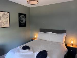 a bedroom with a white bed with two towels and two lights at Teresa's Cottage in Kilcolgan