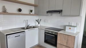 a white kitchen with a sink and a dishwasher at NamibStay Swakop Self Catering in Swakopmund +16 photos