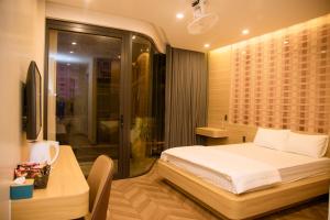 a bedroom with a bed and a table and a shower at Mia Hotel Cửa Lò in Vinh