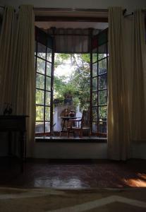 an empty room with a large window with a table and a table at Fort flora in Cochin +52 photos