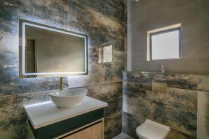 a bathroom with a sink and a mirror at Ditsametse Luxe Suites in Gaborone