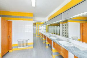 a bathroom with a row of sinks and mirrors at HI Castelo Branco - Pousada de Juventude in Castelo Branco +40 photos