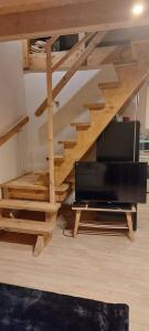 a living room with a staircase with a television at Chata pod kogutem in Barczewko