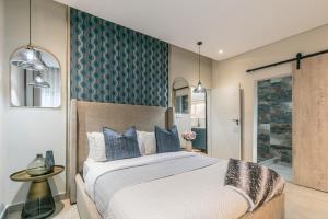 a bedroom with a large bed and a bathroom at Ditsametse Luxe Suites in Gaborone