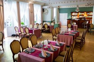 a restaurant with tables and chairs and a bar at Hotel Dwór Sójki in Sójki