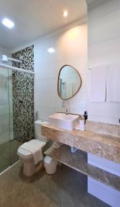 a bathroom with a sink and a toilet and a mirror at Pousada Fenícia in Japaratinga +185 photos