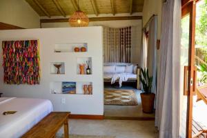 a bedroom with a bed and a room with a bed at Casa Preguiça Corumbau in Corumbau