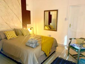 a bedroom with a bed with towels on it at Blue Crane Guesthouse in Hilton