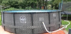 a swimming pool in a cage with a hose at Orange House in Kladenské Rovné