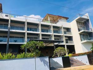 an apartment building with stairs in front of it at Mazarin Hiriketiya in Dickwella