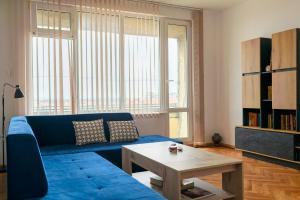 a living room with a blue couch and a table at MIA Apartment in Yambol