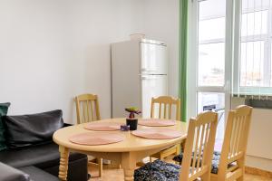 a kitchen with a table with chairs and a refrigerator at MIA Apartment in Yambol