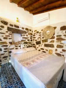 a bedroom with a bed in a stone room at BadeHan Guest House in Çeşme