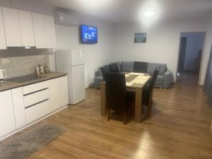 a kitchen and living room with a table and a couch at Casa Lemnarului in Micfalău