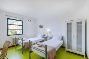 a hospital room with two beds and a window at HI Castelo Branco - Pousada de Juventude in Castelo Branco