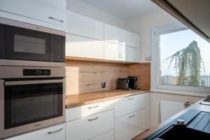 a kitchen with a microwave oven and a window at Jacuzzi, BBQ & EV plug - 5BR Villa Villi with Garden in Limbuš