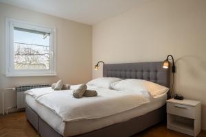 a bedroom with a large white bed with a window at Jacuzzi, BBQ & EV plug - 5BR Villa Villi with Garden in Limbuš
