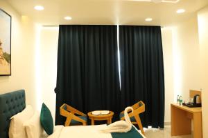 a bedroom with a bed and a black curtain at The Grand Maan Palace and Resort- Near Vaishali Nagar I New Building in Jaipur