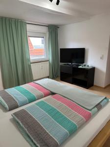 a bedroom with two beds and a television in it at Steinlachquartier in Dußlingen