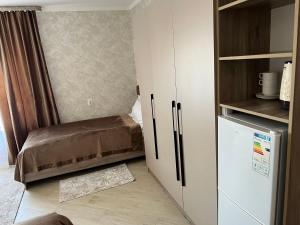 a small room with a bed and a closet at KOLESEY Hotel in Taldykorgan +16 photos