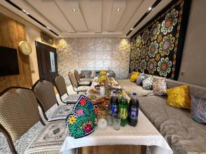 a dining room with a long table and chairs with bottles at Guest house Homely in Dushanbe