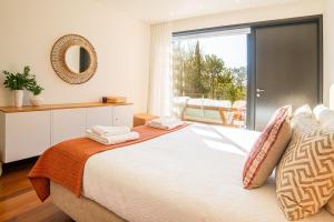 a bedroom with a large bed and a large window at Troia Ocean Breeze Villa in Troia +65 photos