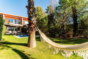 a hammock in a yard next to a house at Troia Ocean Breeze Villa in Troia