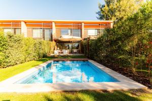 a swimming pool in the backyard of a house at Troia Ocean Breeze Villa in Troia