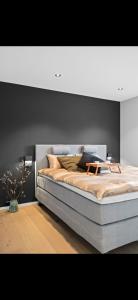 a bedroom with a large bed with a gray headboard at Sentral og moderne base i Lofoten in Vestvågøya