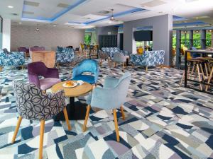 a lobby with colorful chairs and tables in a room at ibis Styles Crewe in Crewe