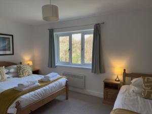 a bedroom with two beds and a window at Beachcomber in Croyde