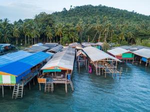 a group of houses on the water with trees at Tabebuia House ทาเบบูย่าเฮ้าส์ in Pathiu