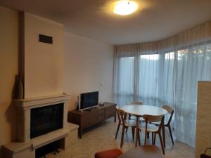 a living room with a table and a television at Апартамент за гости Манчев in Stoykite
