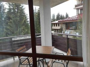 a balcony with a table and chairs and a window at Апартамент за гости Манчев in Stoykite