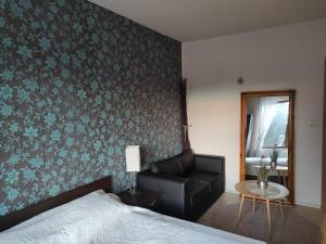 a bedroom with a bed and a chair and a table at Апартамент за гости Манчев in Stoykite
