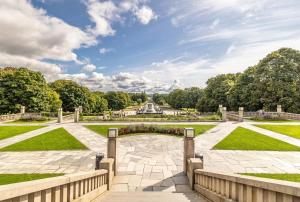 a view of a park with a fountain in the distance at Prime Central Oslo - Frogner, All-Inclusive Apartment in Oslo