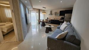 a living room with a blue couch and a kitchen at Orins place eilat in Eilat