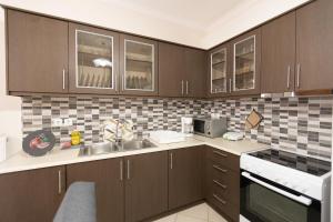 a kitchen with brown cabinets and a sink at Nikorina apts in Lefkada