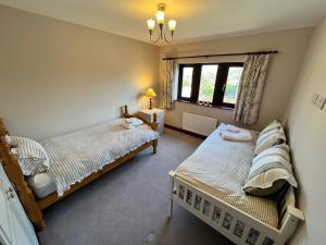 a bedroom with two beds and a window at The Peak View - Holmfirth in Cartworth