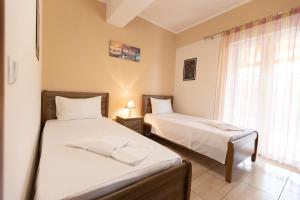 a bedroom with two beds and a window at Nikorina apts in Lefkada +61 photos