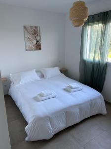 a white bed with two towels on top of it at Résidence A Traggina in Prunelli-di-Fiumorbo